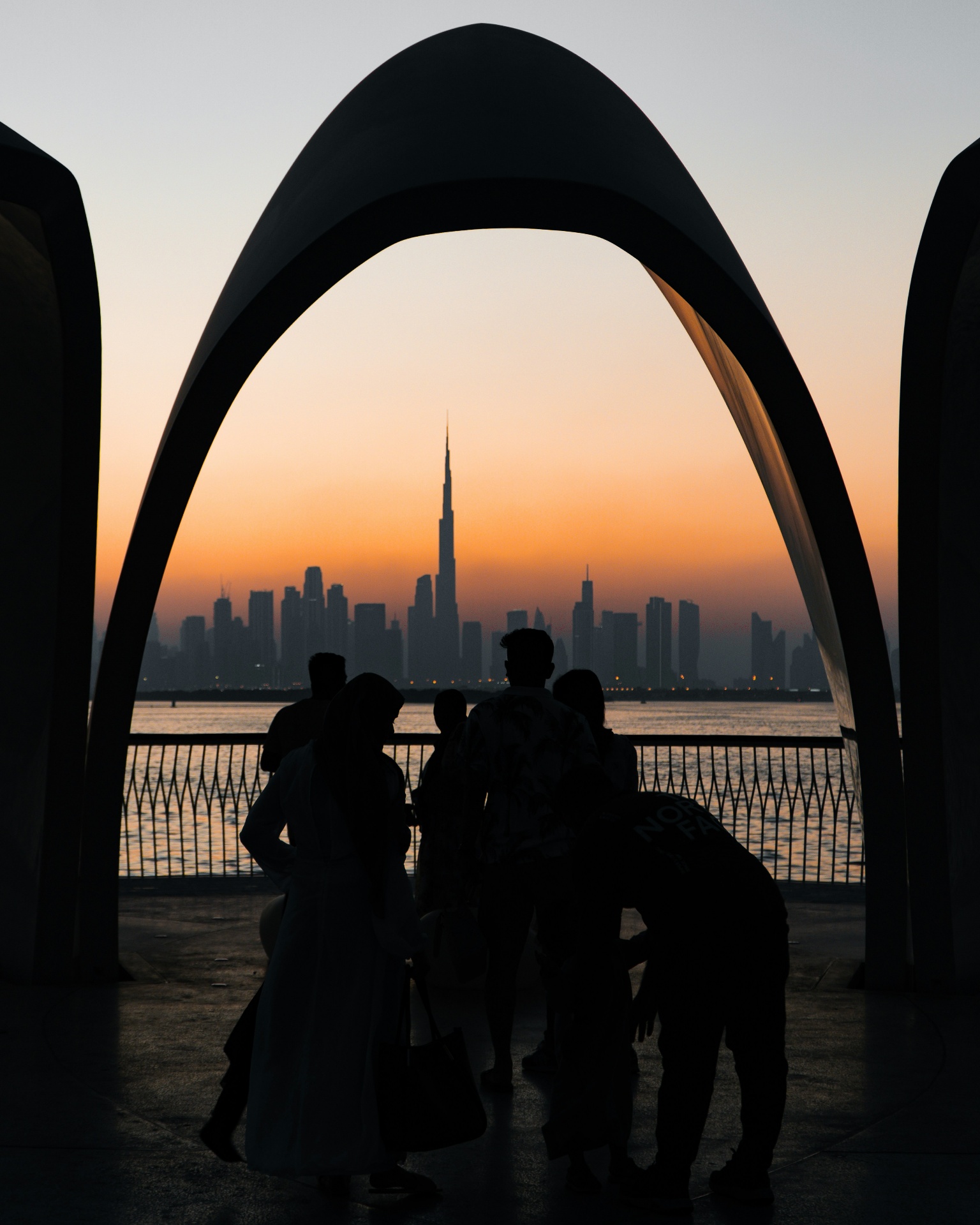 Architectural arch framing a city skyline at sunset